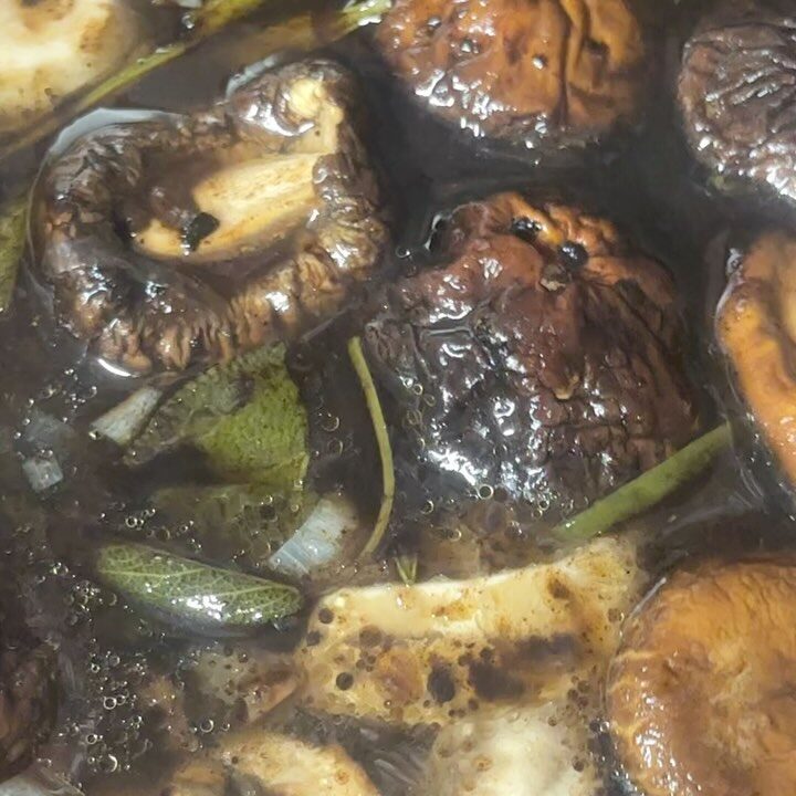 Dark mushroom bone broth with shiitake and sage, close-up