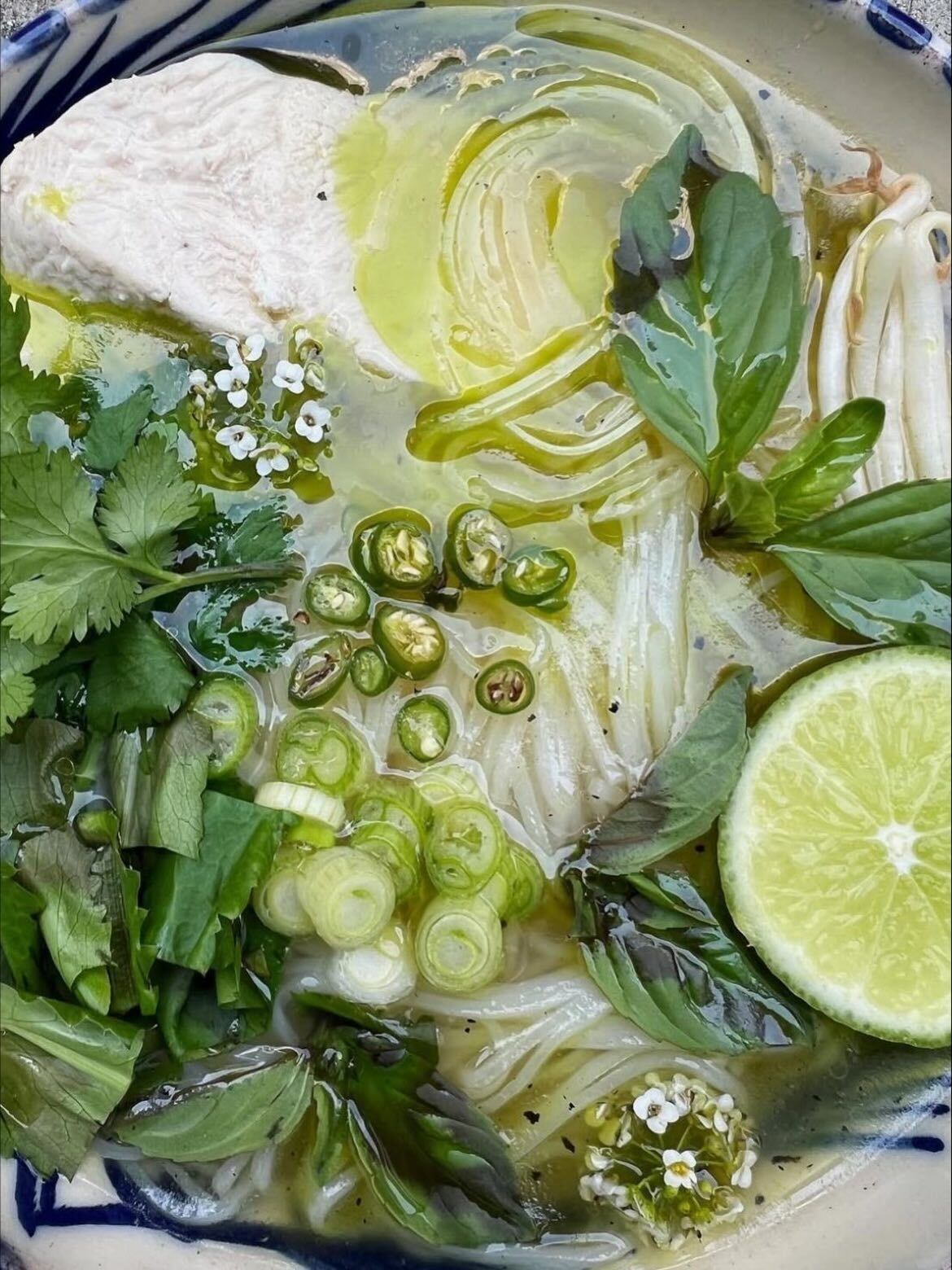 Green herb-and-broth bowl with basil, scallion and lime, top-down