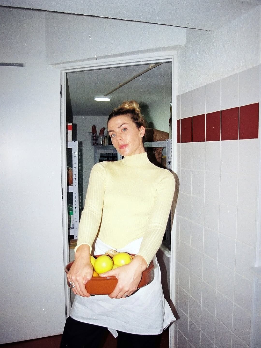 Sinead in the Lisbon kitchen with citrus and produce on the counter, morning light