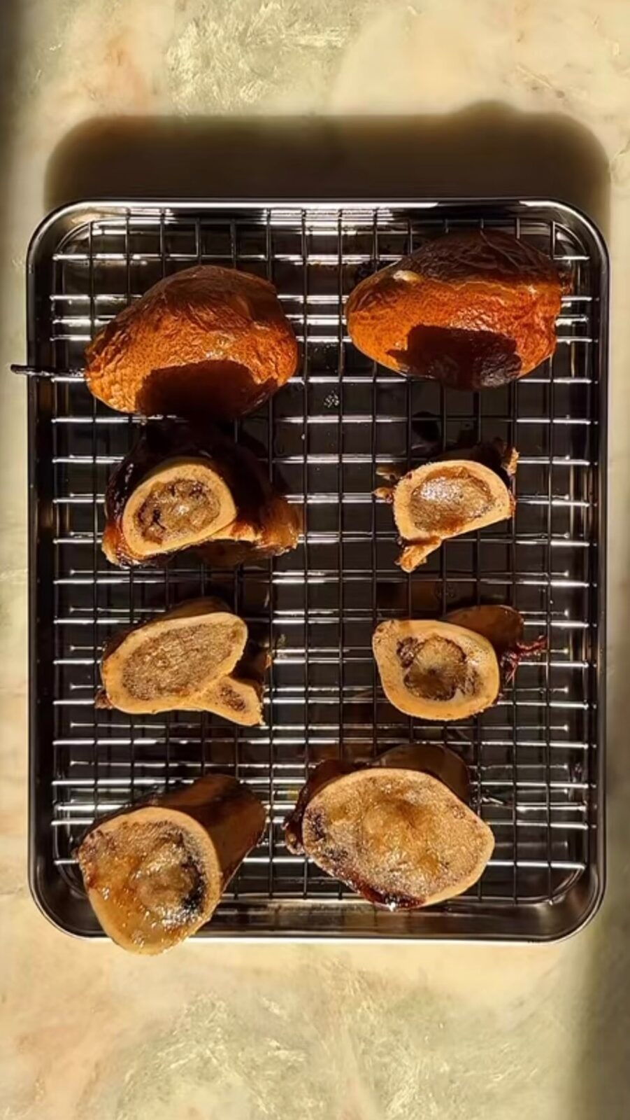 Roasted grass-fed beef marrow bones halved on a tray