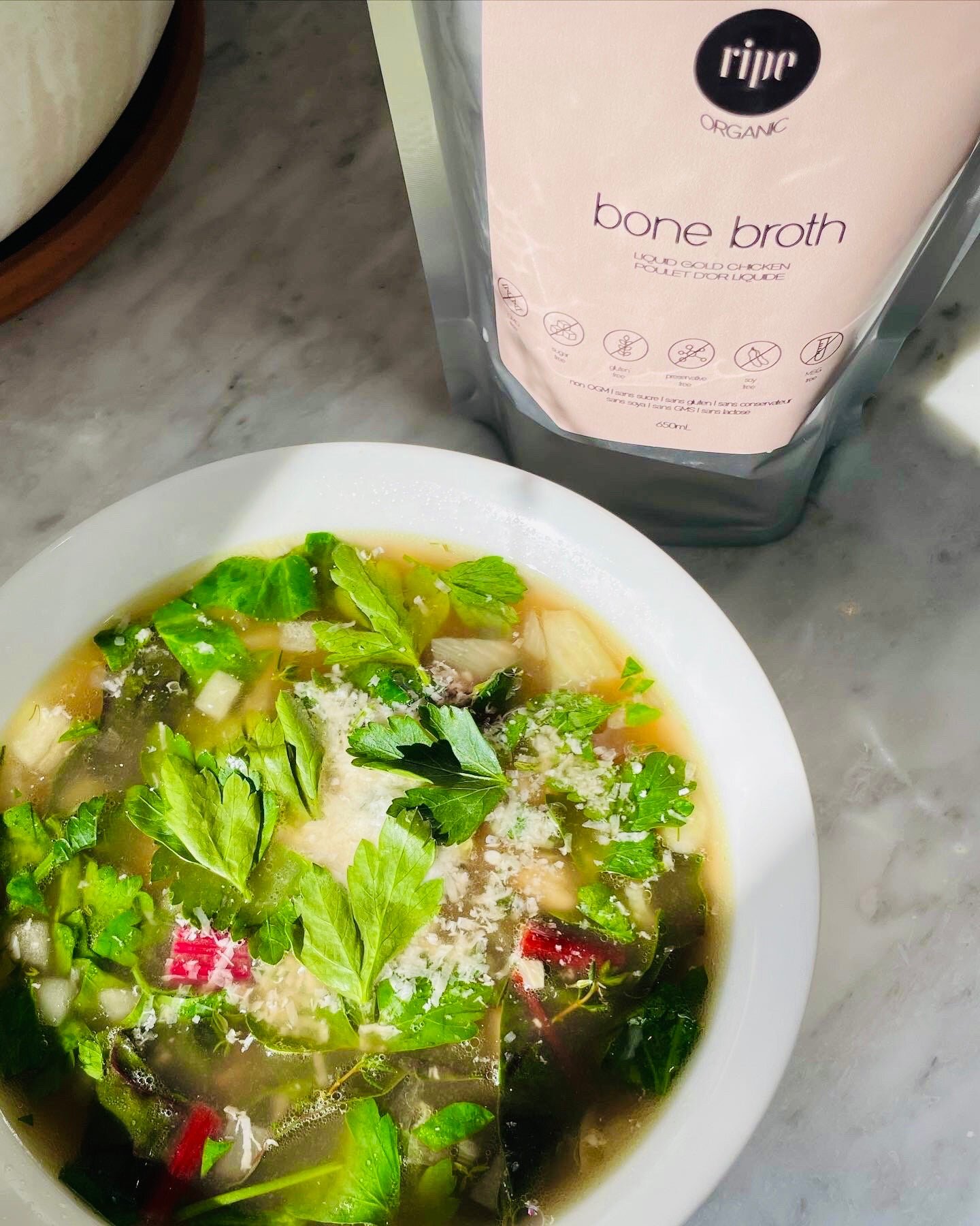 A bowl of golden bean and fennel soup with grated Parmesan