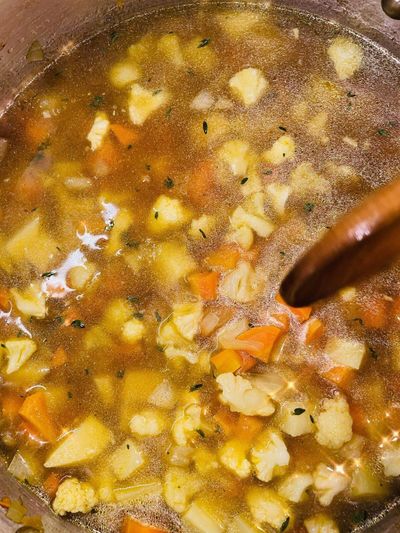 Bowl of chicken pot pie soup with diced chicken, peas and root vegetables — RIPE Europe recipe