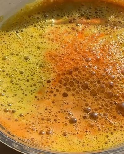Golden turmeric broth bubbles swirling close-up