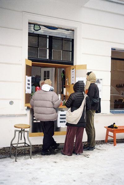 Three customers gathered at the RIPE Lifestyle Europe Berlin pop-up window, paper cups of warm broth in hand