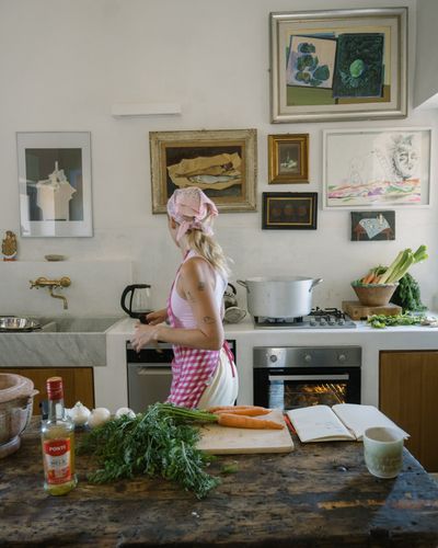 Sinead McInerney looking back over her shoulder at the prep station in the RIPE Lifestyle Europe Lisbon kitchen — celery, onions and the spice rack in frame
