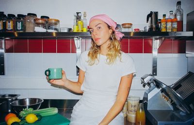 Sinead McInerney with a mug of ginger-and-lemon broth in the RIPE Lisbon kitchen, citrus and RIPE bottles in the foreground