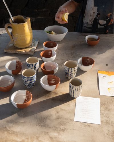 RIPE ginger-and-lemon broth served at Parco dei Sesi — handmade ceramic cups, fresh lemon squeezed over the broth